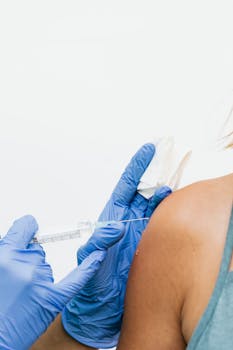 Close-up of a healthcare professional administering a vaccination using a syringe and gloves.