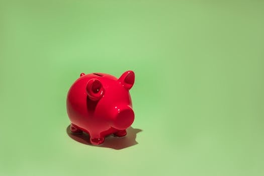 Red piggy bank on a green background symbolizing savings and financial planning.